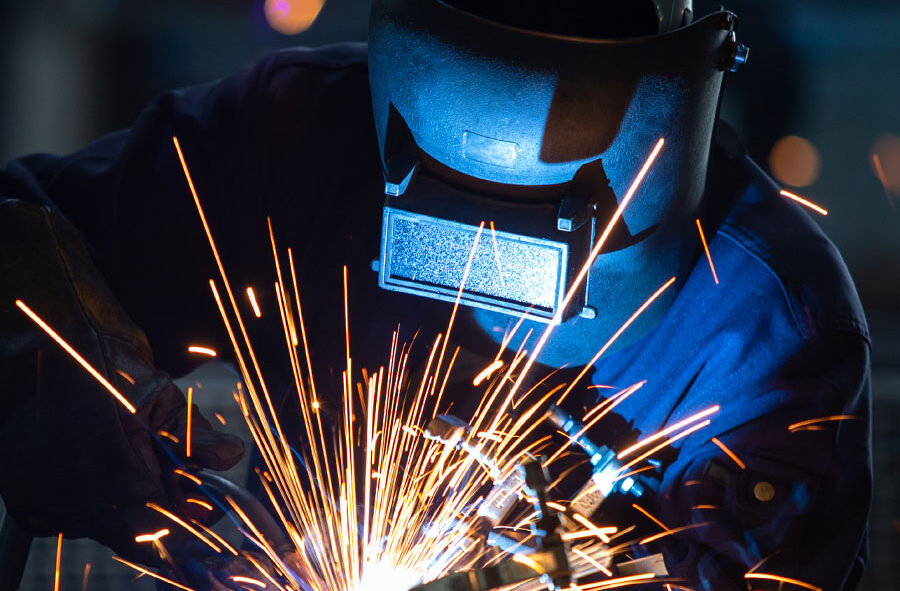 man with a protective mask welding metal